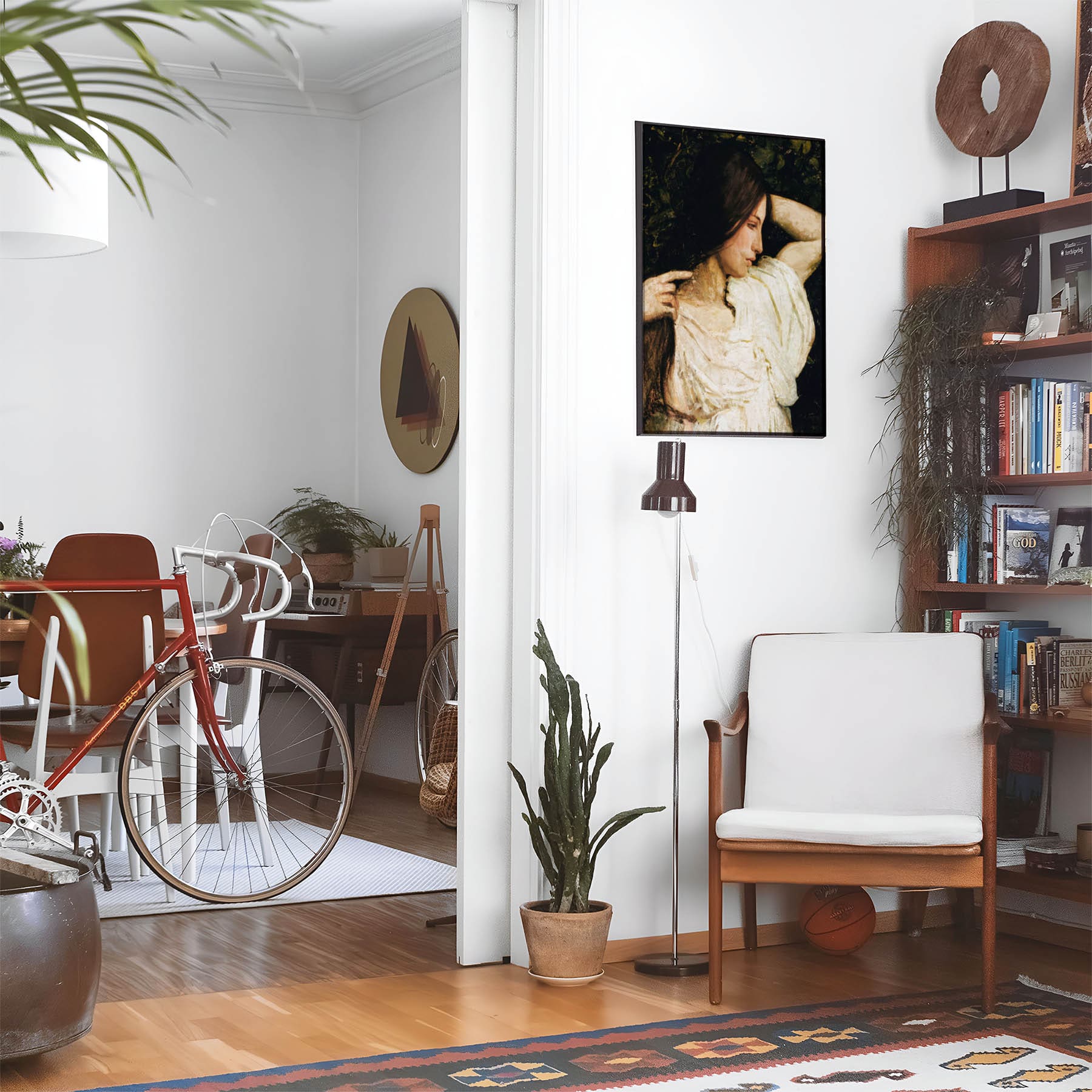 Eclectic living room with a road bike, bookshelf and house plants that features framed artwork of a Dark Hair Girl in White above a chair and lamp