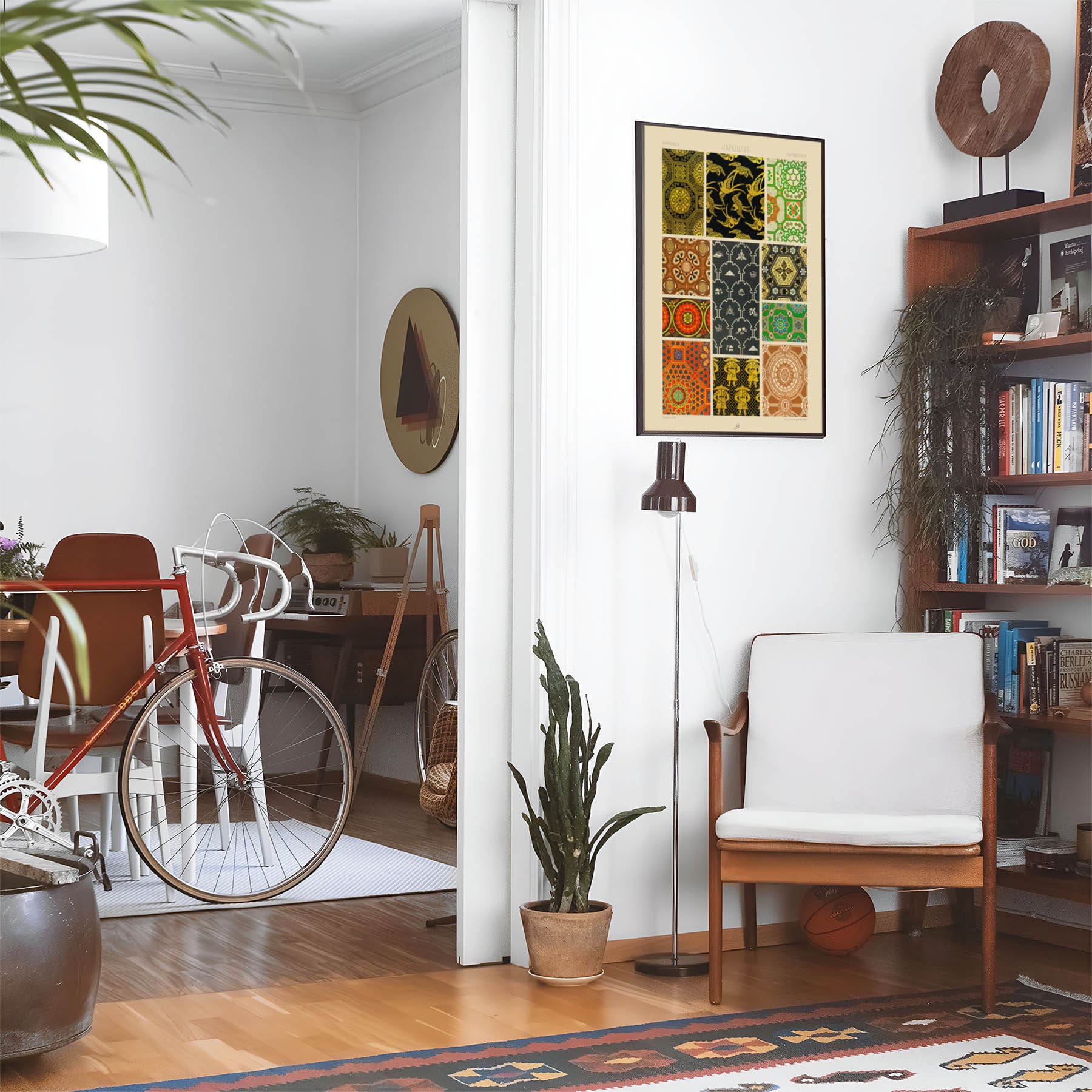Eclectic living room with a road bike, bookshelf and house plants that features framed artwork of a Pattern Samples above a chair and lamp