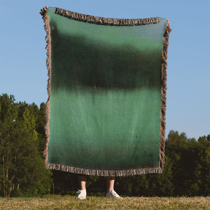 Black and Green Woven Blanket Held Up Outside