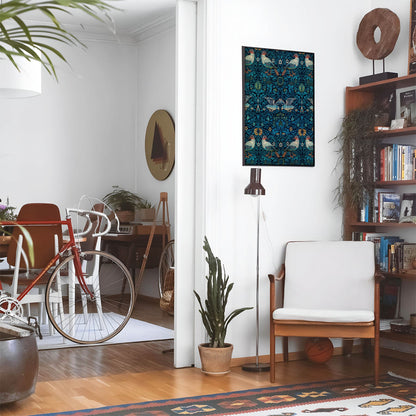 Living space with a black leather couch and table with a plant and books below a staircase featuring a framed picture of Birds and Plants