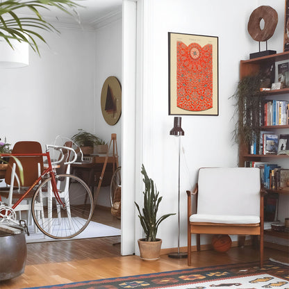 Eclectic living room with a road bike, bookshelf and house plants that features framed artwork of a Design Sample above a chair and lamp