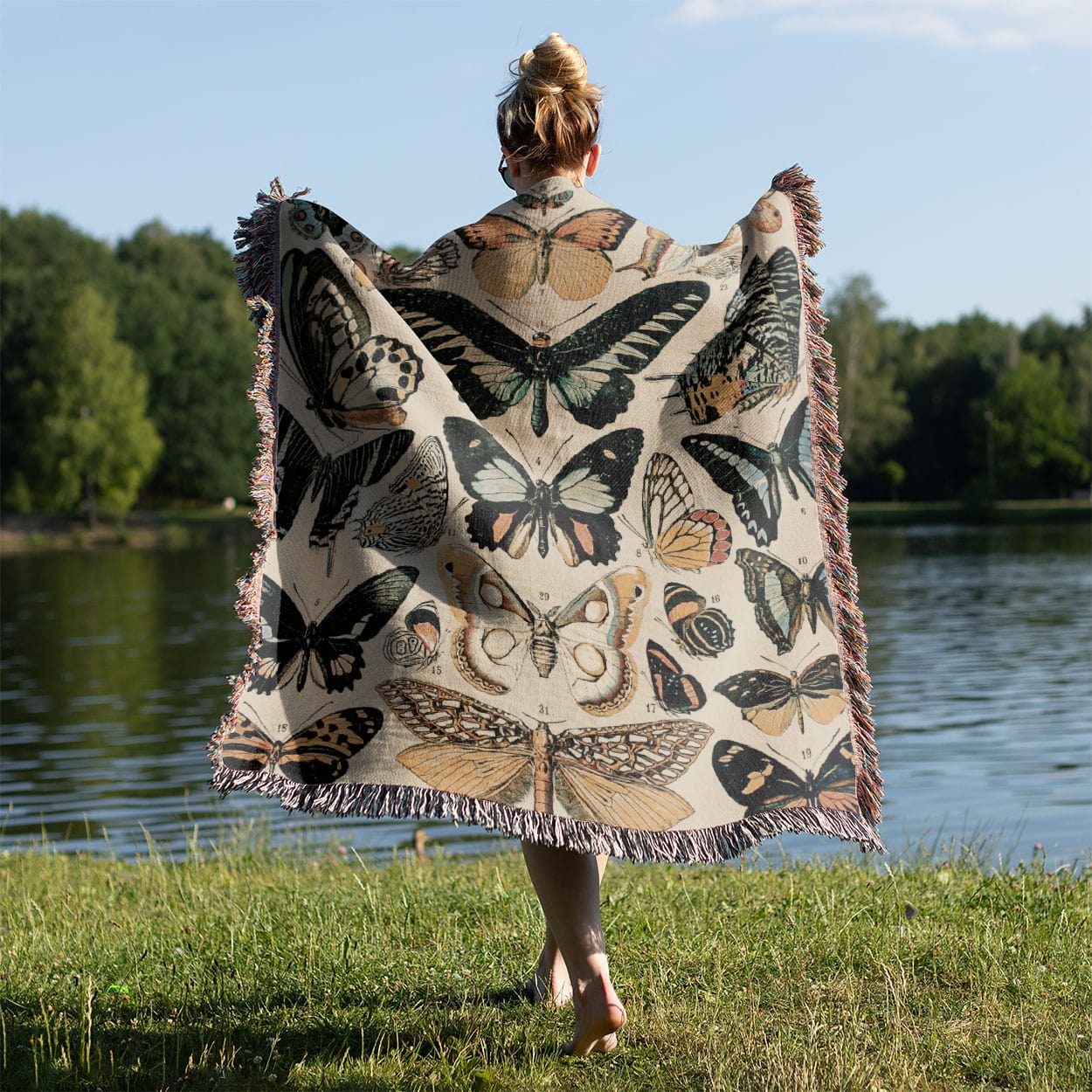 Butterflies and Moths Woven Throw Blanket Held on a Woman's Back Outside