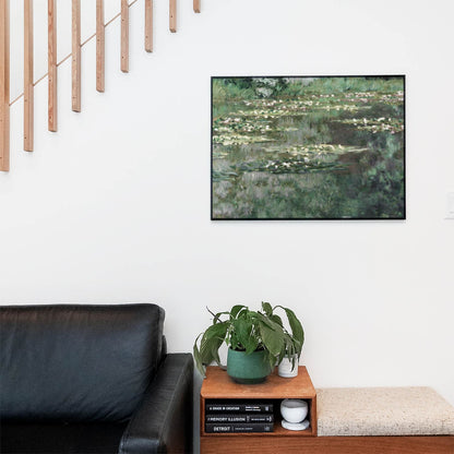 Living space with a black leather couch and table with a plant and books below a staircase featuring a framed picture of Lush Green Impressionist