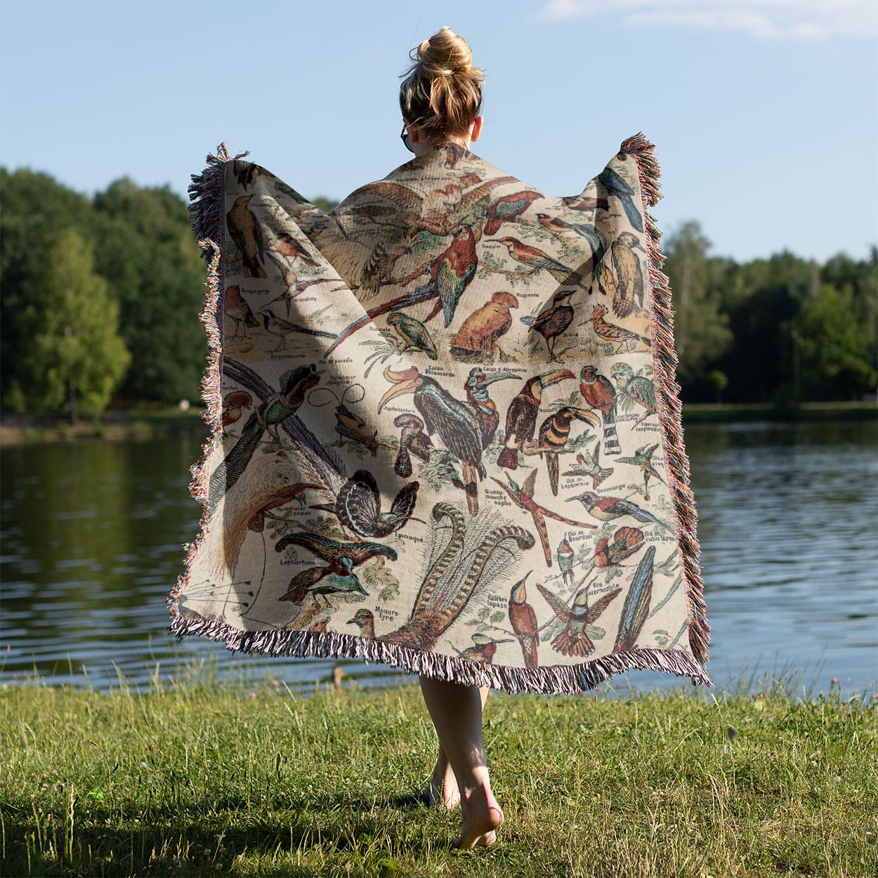 Collection of Birds Woven Throw Blanket Held on a Woman's Back Outside