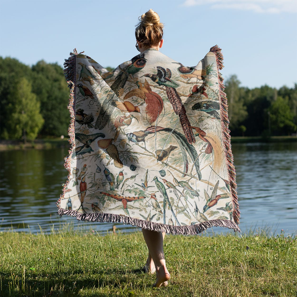 Collection of Birds Woven Blanket Held on a Woman's Back Outside
