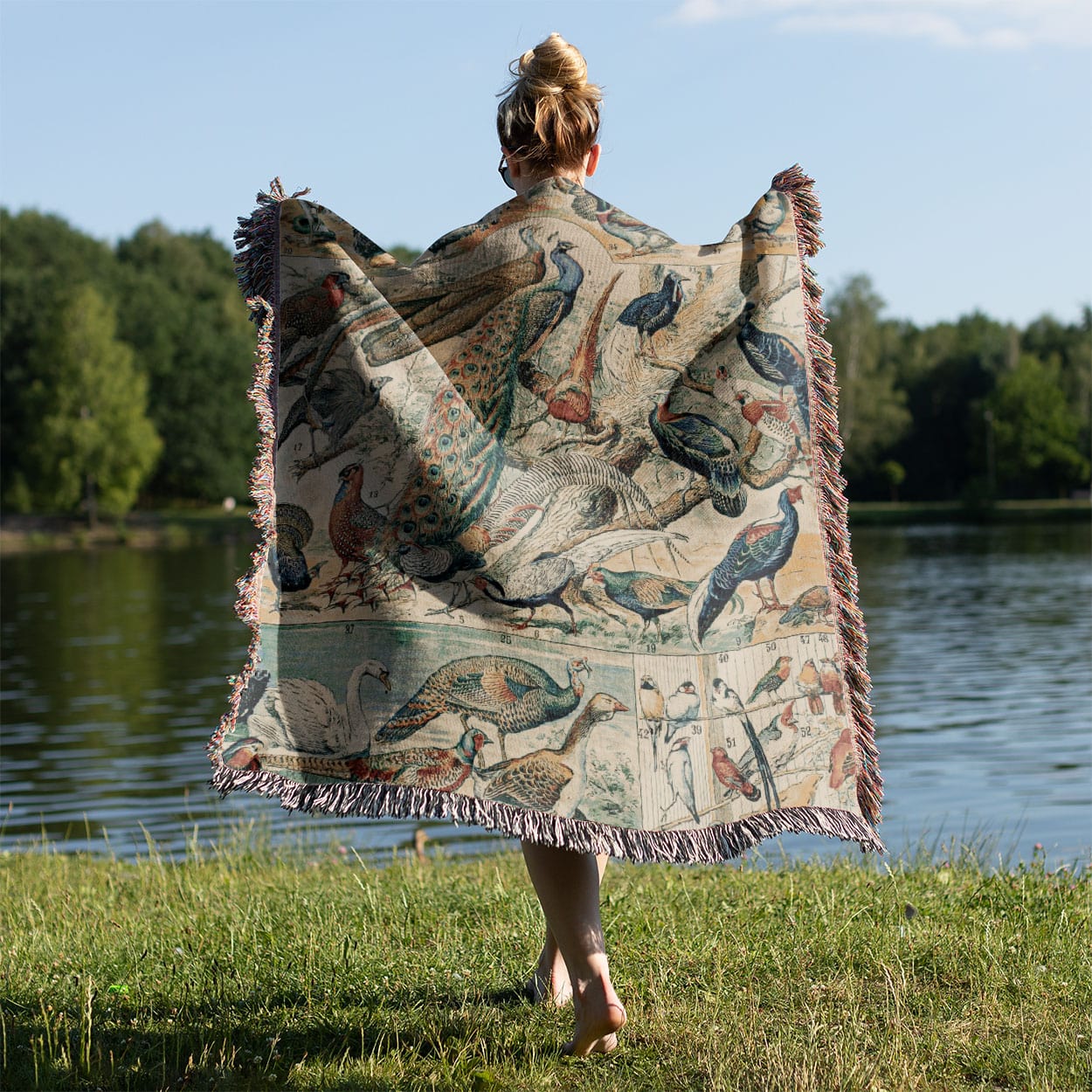 Collection of Birds Woven Throw Blanket Held on a Woman's Back Outside