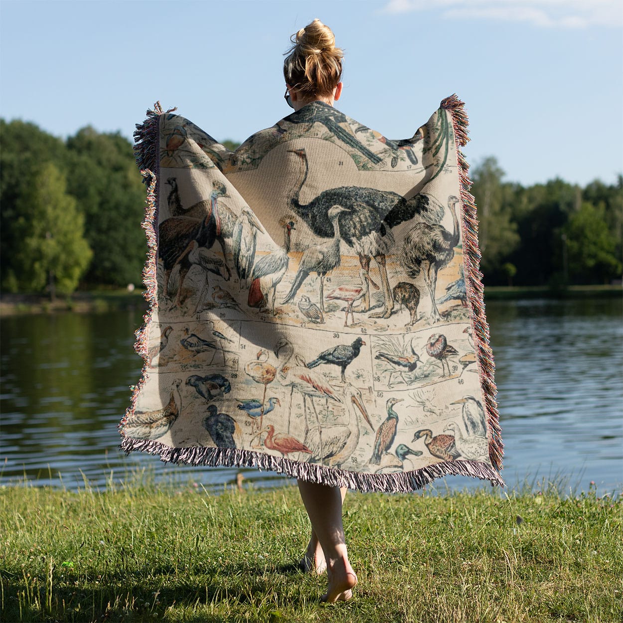 Collection of Birds Woven Throw Blanket Held on a Woman's Back Outside