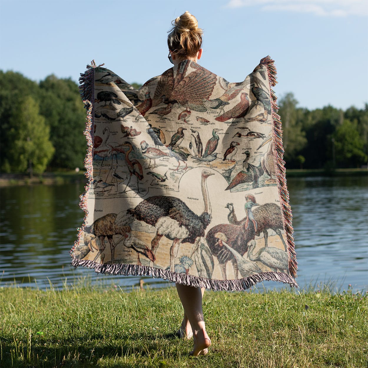 Collection of Birds Woven Throw Blanket Held on a Woman's Back Outside