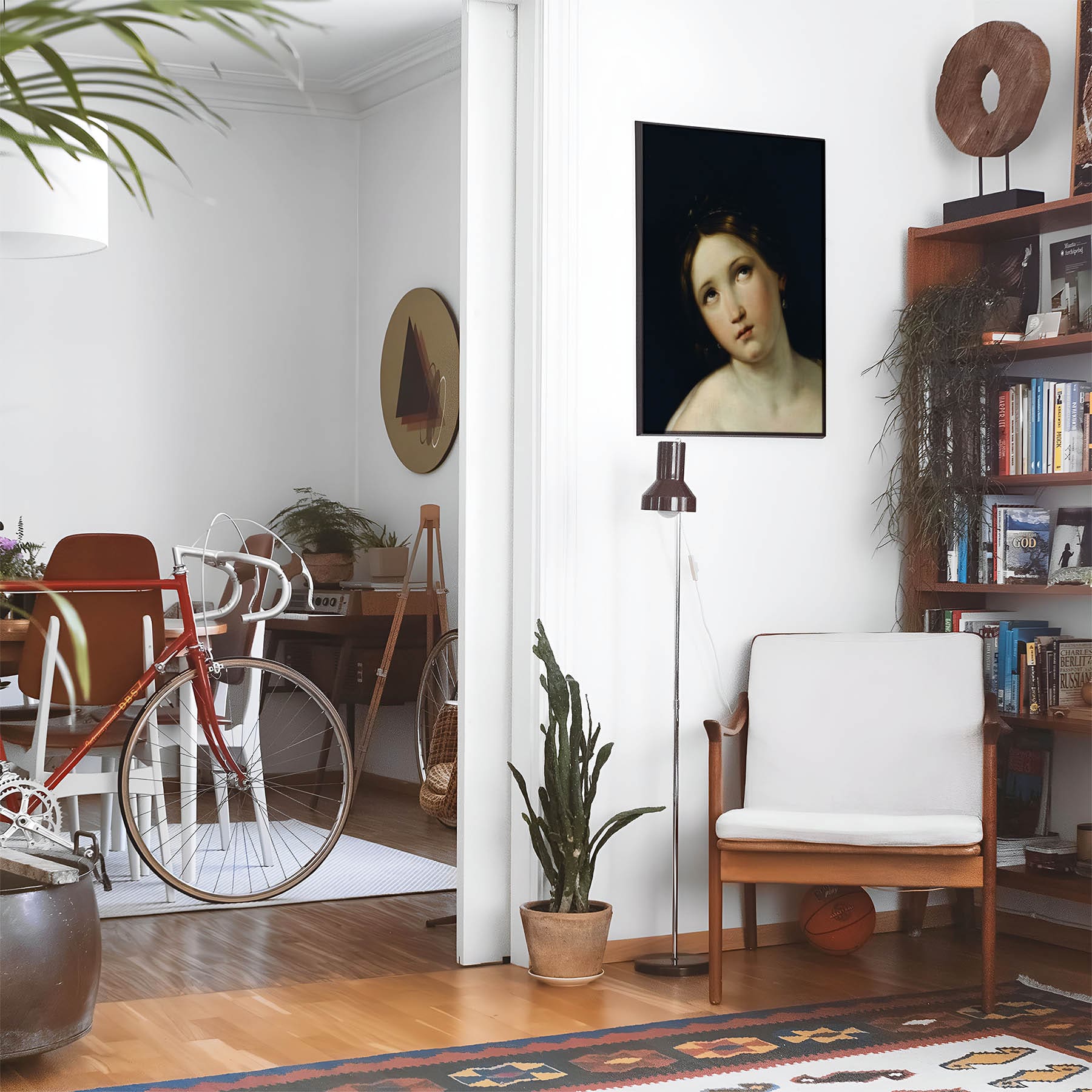 Eclectic living room with a road bike, bookshelf and house plants that features framed artwork of a Aesthetic Dark and Moody above a chair and lamp