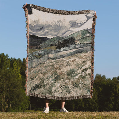 Dark Cloudy Hillside Woven Throw Blanket Held Up Outside