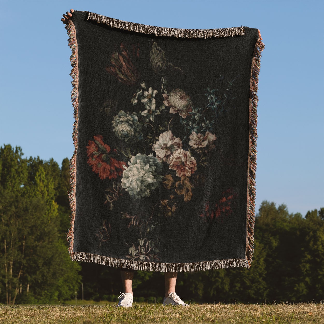 Dark Floral Woven Blanket Held Up Outside