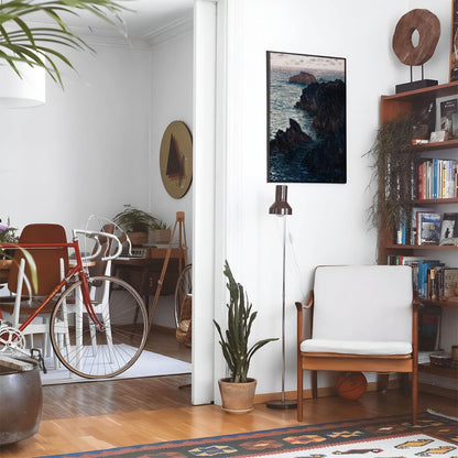 Eclectic living room with a road bike, bookshelf and house plants that features framed artwork of a Rocky Cliffs on the Ocean above a chair and lamp