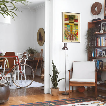 Eclectic living room with a road bike, bookshelf and house plants that features framed artwork of a Unique Colors and Patterns above a chair and lamp