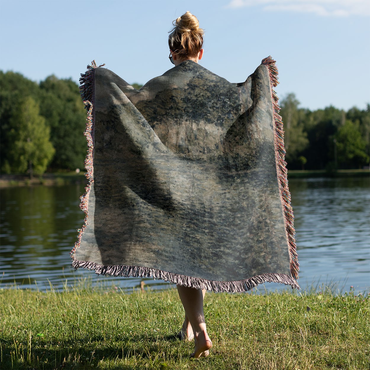 Dusty Sage Landscape Woven Throw Blanket Held on a Woman's Back Outside