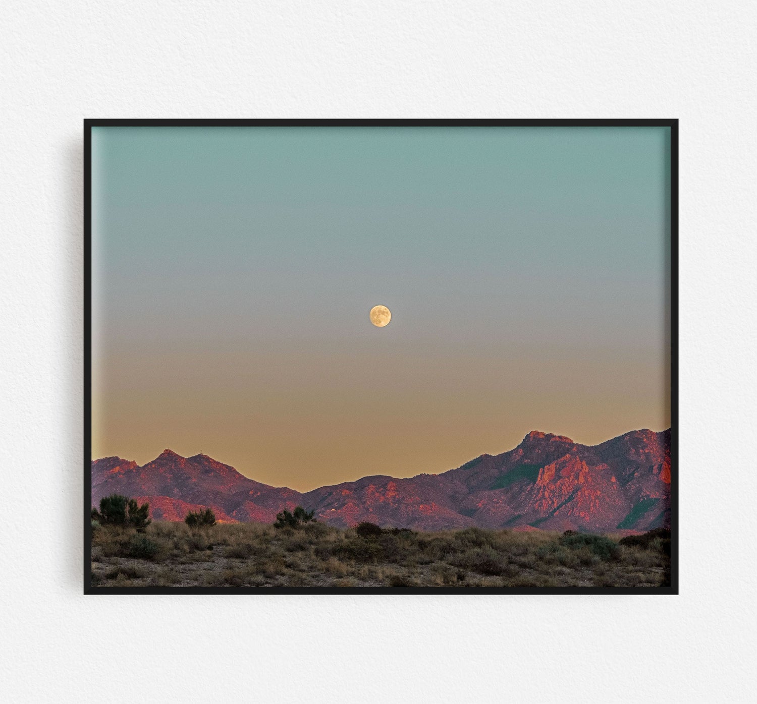 Picture of sunset and moon in a black frame