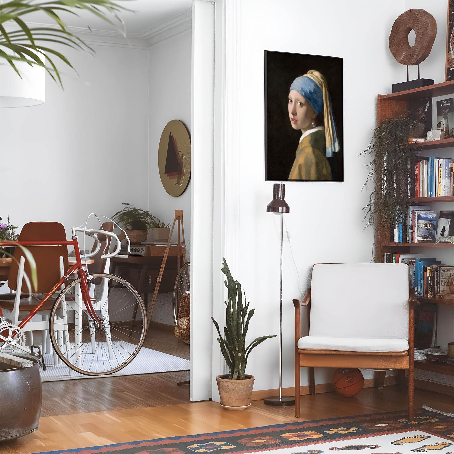 Eclectic living room with a road bike, bookshelf and house plants that features framed artwork of a Famous Vermeer above a chair and lamp