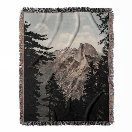 Forest and Mountains Woven Blanket Held on a Woman's Back Outside