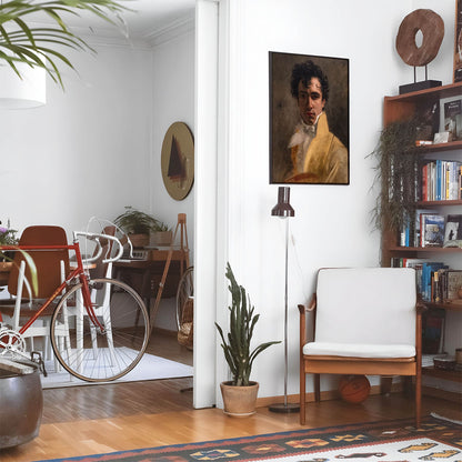 Eclectic living room with a road bike, bookshelf and house plants that features framed artwork of a Handsome Old Fashion Gentleman above a chair and lamp