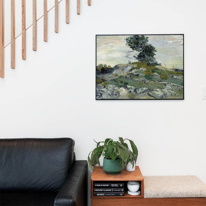 Living space with a black leather couch and table with a plant and books below a staircase featuring a framed picture of Brushstrokes of Nature
