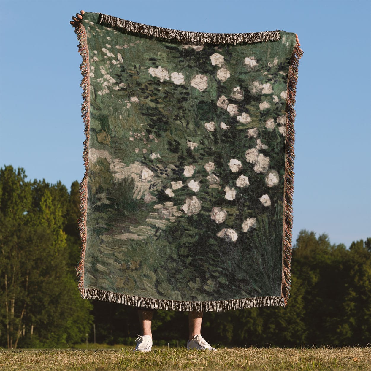 Green with White Flowers Woven Throw Blanket Held Up Outside