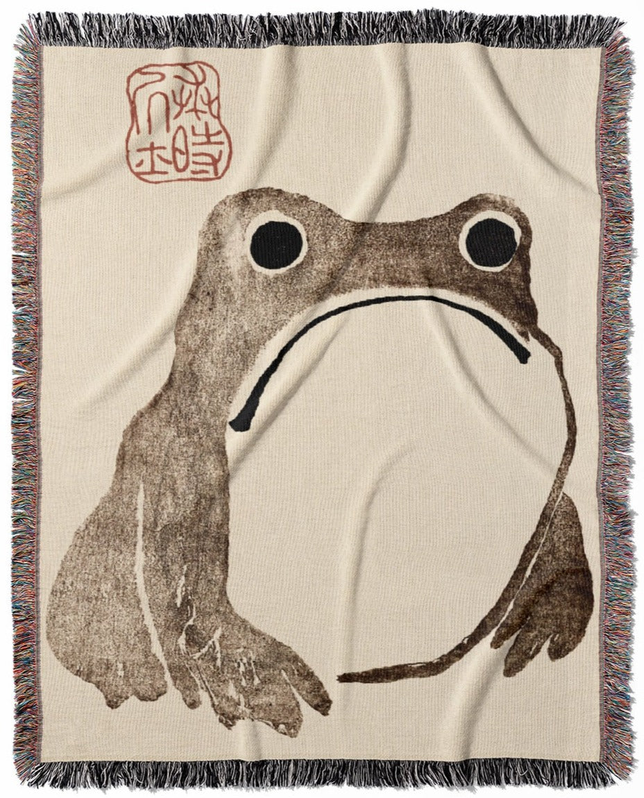 Grumpy Frog woven throw blanket, made with 100% cotton, offering a soft and cozy texture with a humorous sad frog design for home decor.