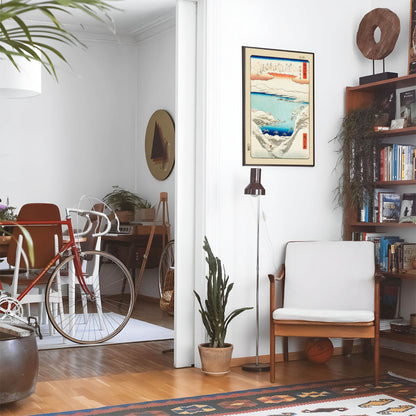 Eclectic living room with a road bike, bookshelf and house plants that features framed artwork of a Mountains Woodblock above a chair and lamp