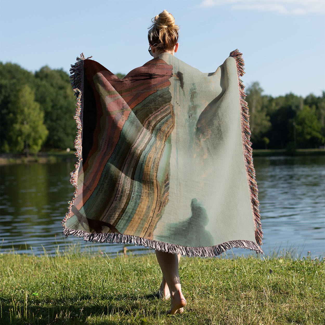 Layers of the Earth Woven Throw Blanket Held on a Woman's Back Outside