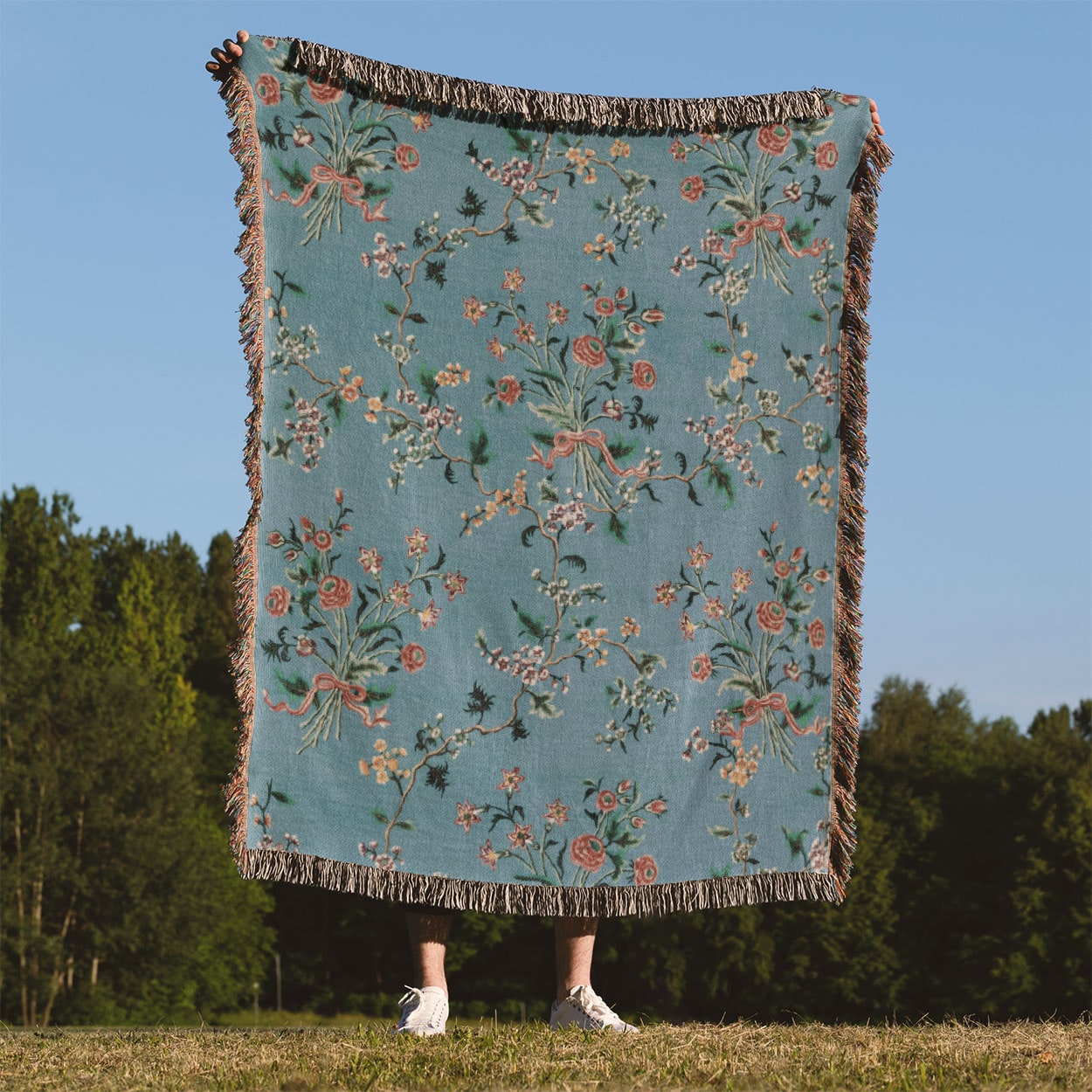Light Floral Woven Blanket Held on a Woman's Back Outside