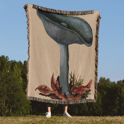 Little Blue Mushrooms Woven Throw Blanket Held Up Outside