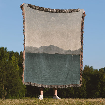 Minimalist Mountains Woven Blanket Held on a Woman's Back Outside
