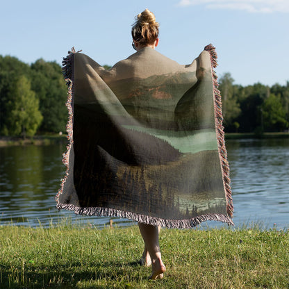 Mountains Woven Throw Blanket Held on a Woman's Back Outside