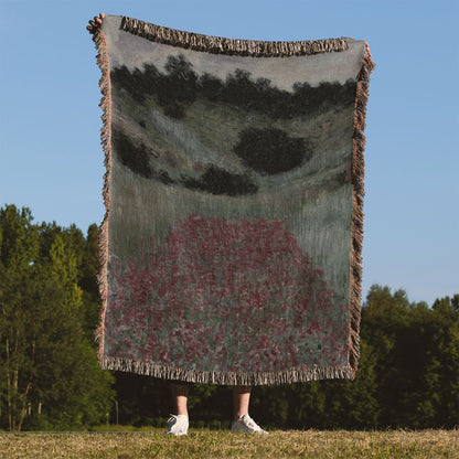 Muted Floral Landscape Woven Blanket Held on a Woman's Back Outside