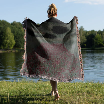 Muted Floral Landscape Woven Throw Blanket Held on a Woman's Back Outside