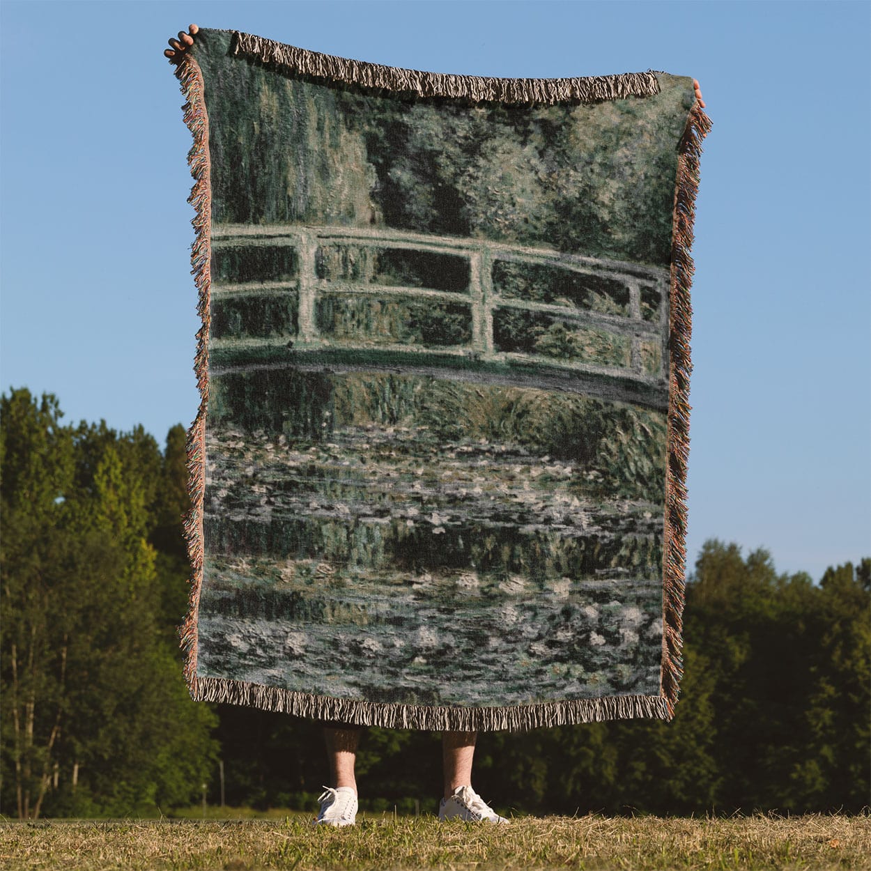 Muted Sage Green Woven Blanket Held on a Woman's Back Outside