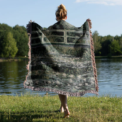 Muted Sage Green Woven Throw Blanket Held on a Woman's Back Outside