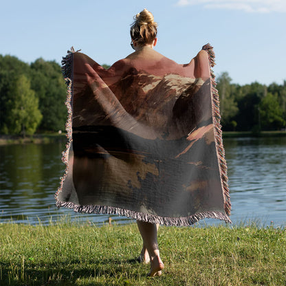 Red Mountain Sunset Woven Blanket Held on a Woman's Back Outside