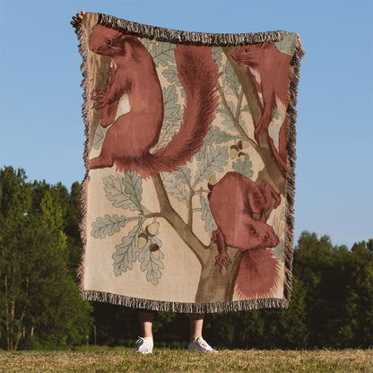 Red Squirrels Woven Blanket Held Up Outside