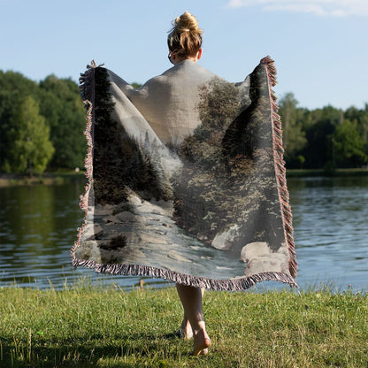 River Woven Blanket Held on a Woman's Back Outside