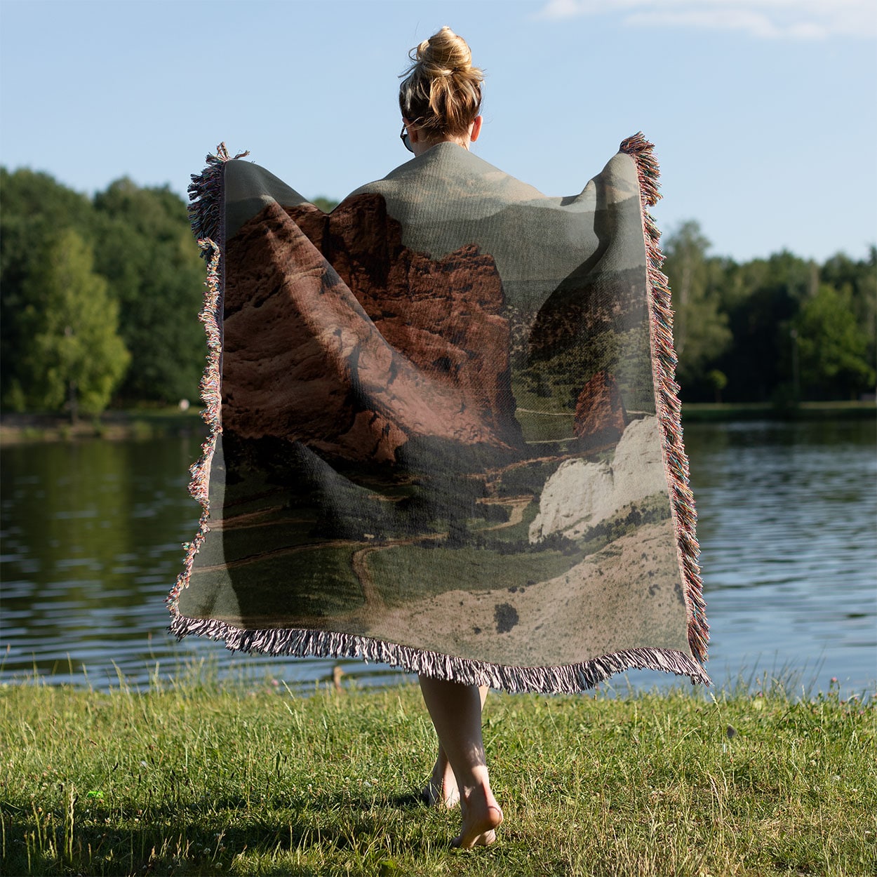 The Gateway Woven Blanket Held on a Woman's Back Outside