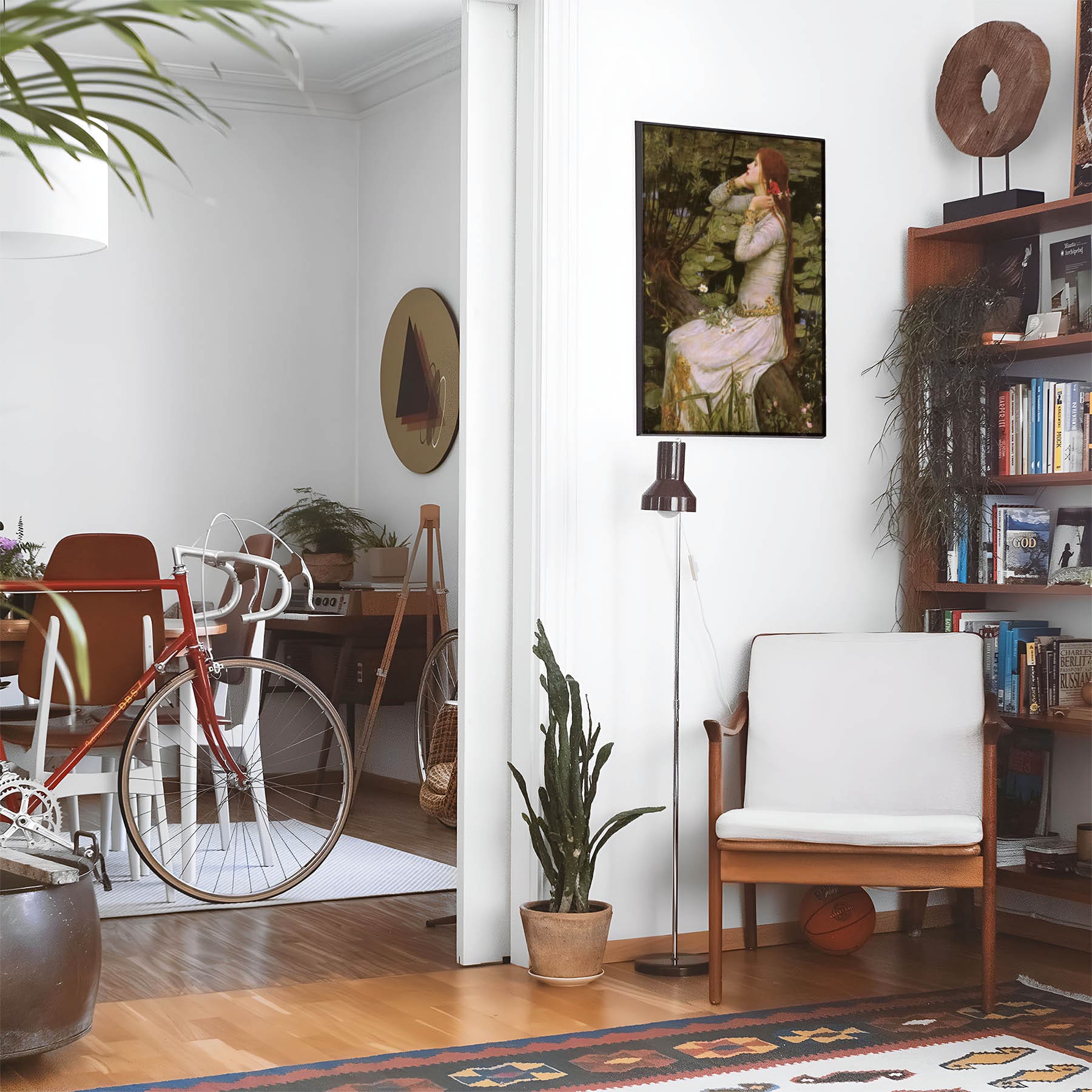 Eclectic living room with a road bike, bookshelf and house plants that features framed artwork of a Girl with Red Hair and White Dress above a chair and lamp