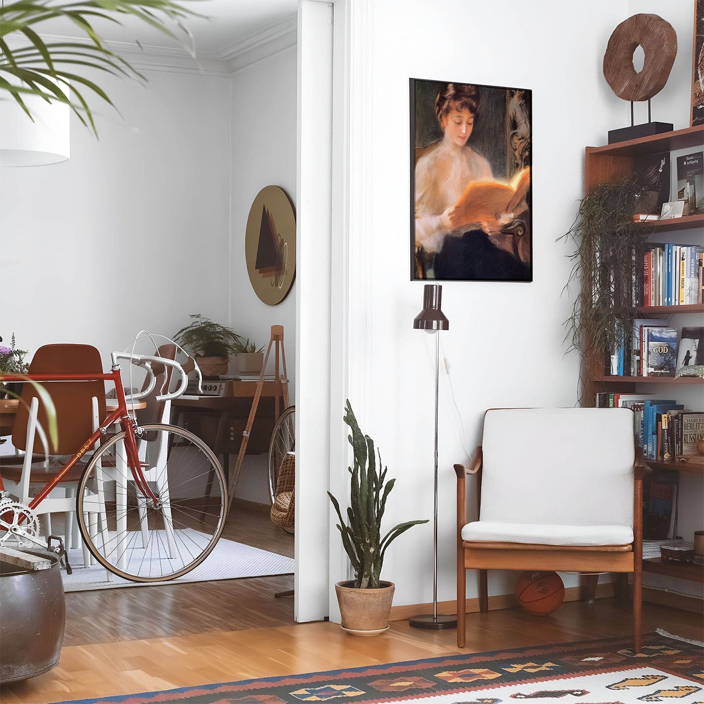 Eclectic living room with a road bike, bookshelf and house plants that features framed artwork of a Aesthetic Reading above a chair and lamp
