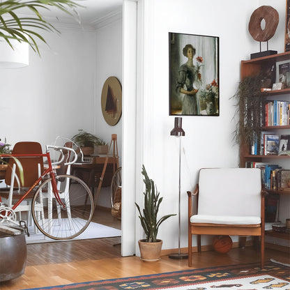 Living space with a black leather couch and table with a plant and books below a staircase featuring a framed picture of Impressionism Portrait