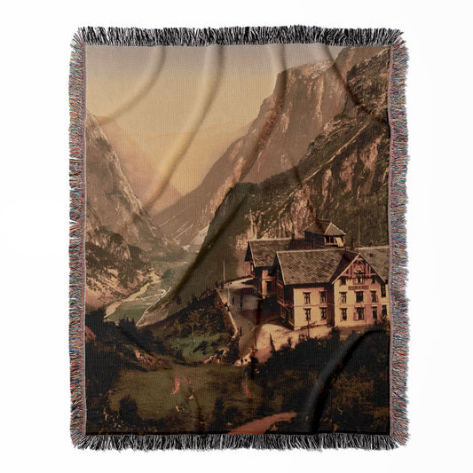Vintage Mountain Hotel woven throw blanket, made with 100% cotton, providing a soft and cozy texture with a scenic landscape for home decor.