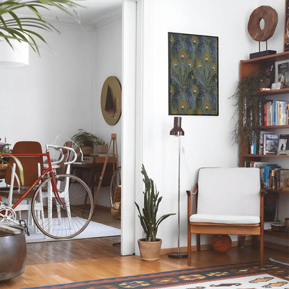 Eclectic living room with a road bike, bookshelf and house plants that features framed artwork of a Colorful Feather above a chair and lamp