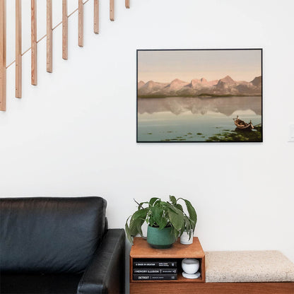 Living space with a black leather couch and table with a plant and books below a staircase featuring a framed picture of Mountains on a Lake