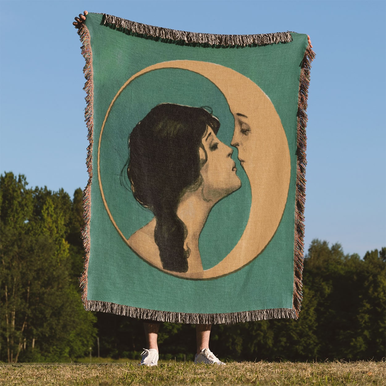 Woman Kissing the Moon Woven Blanket Held Up Outside