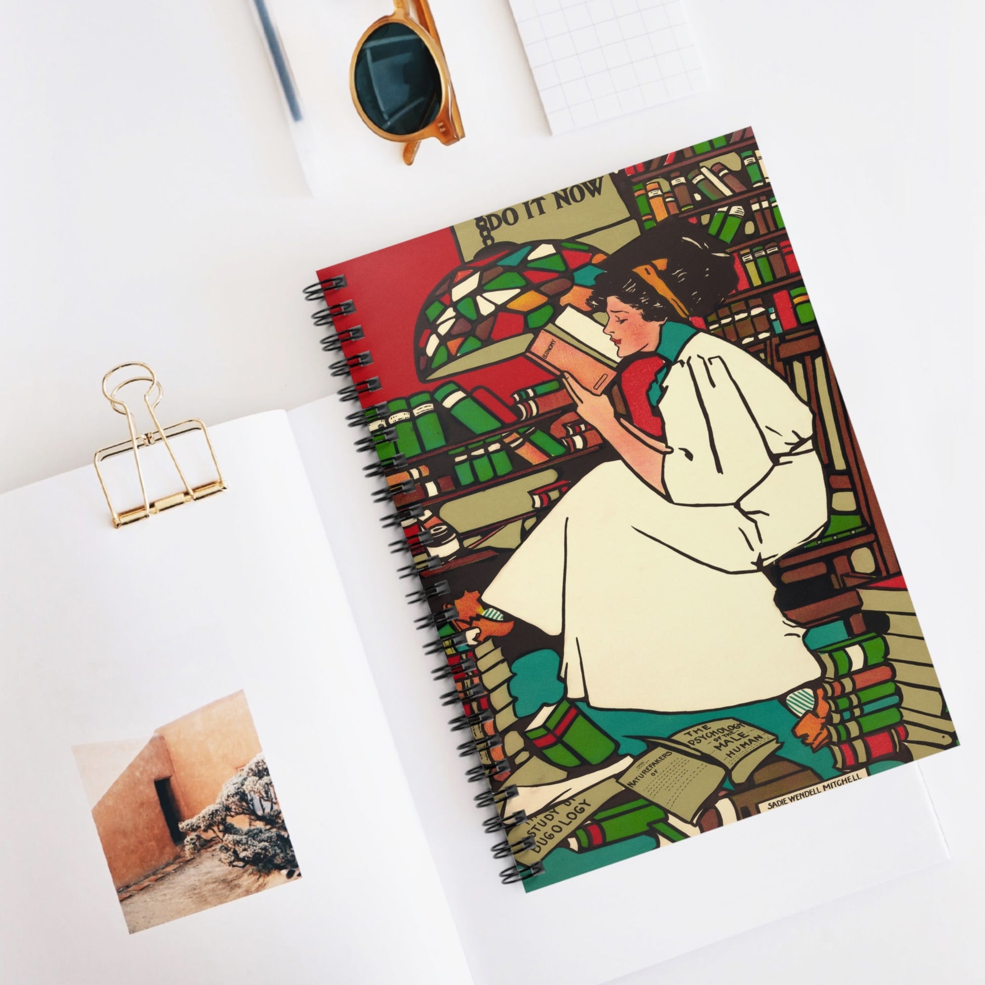 Woman Reading Spiral Notebook Displayed on Desk