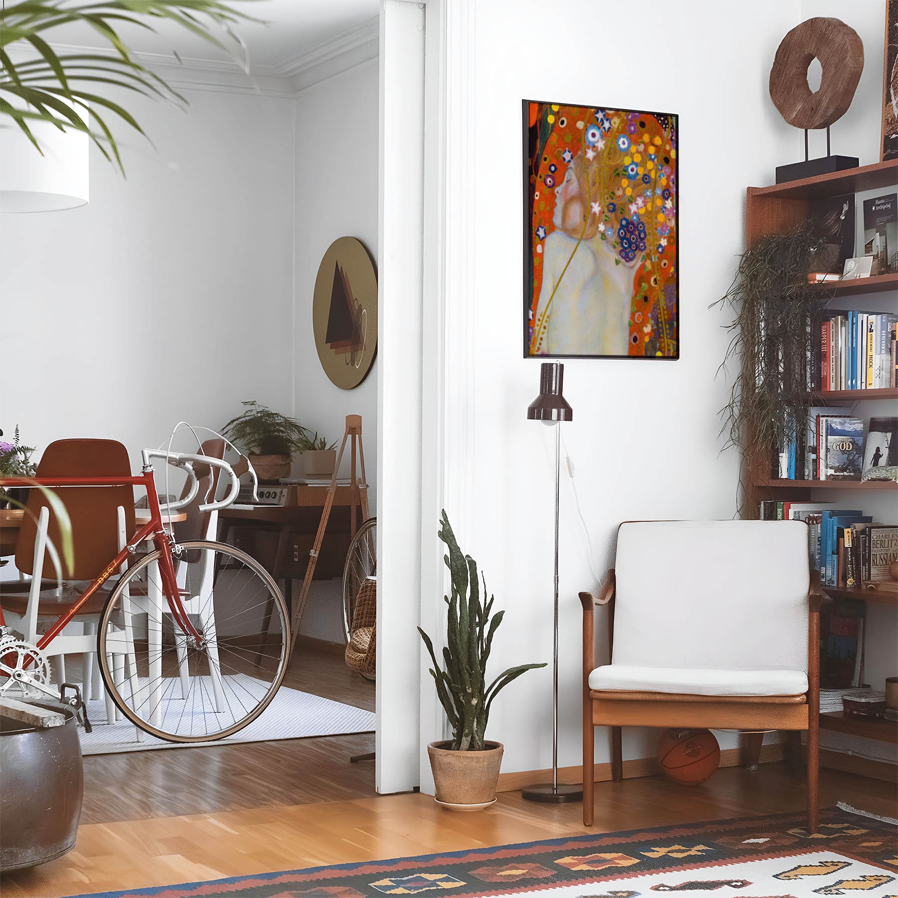 Eclectic living room with a road bike, bookshelf and house plants that features framed artwork of a Boho Aesthetic above a chair and lamp